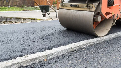 A roller going over recently laid tarmac